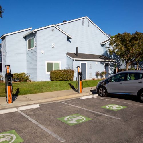 An electric car being charged at a multifamily EV charging station